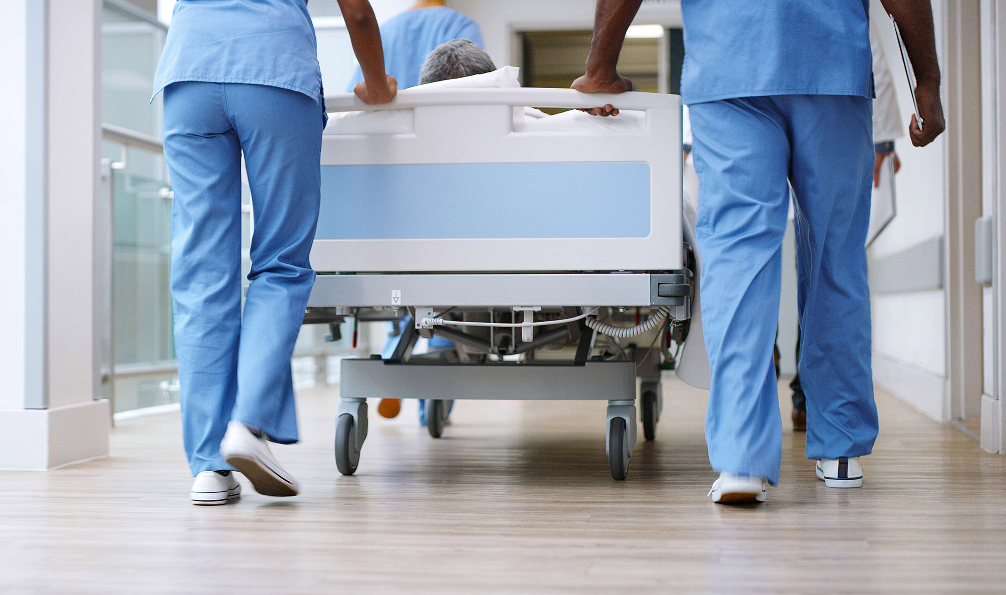 Nurses pushing a hospital bed.