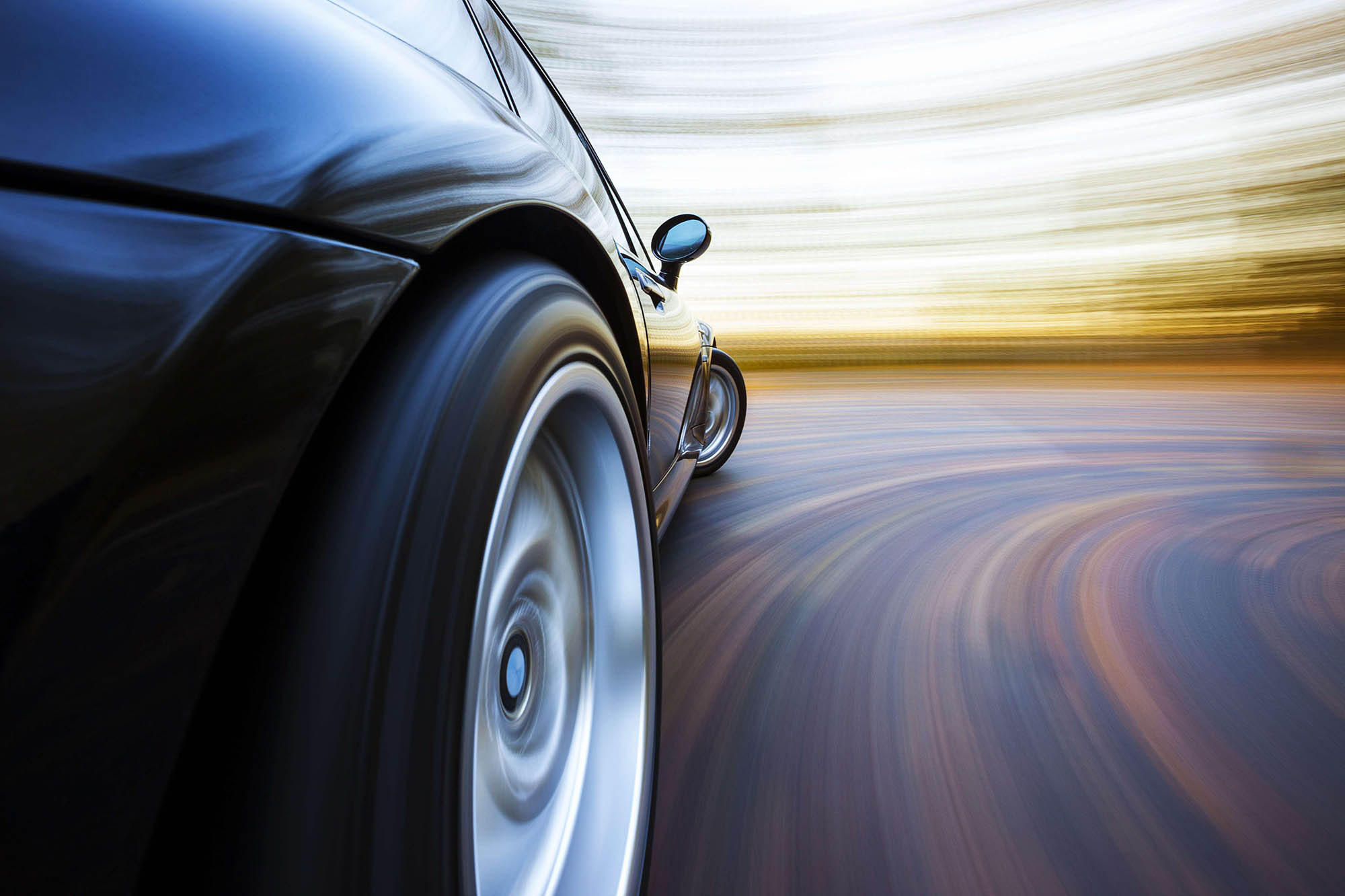 Blurry image of a car wheel in motion.